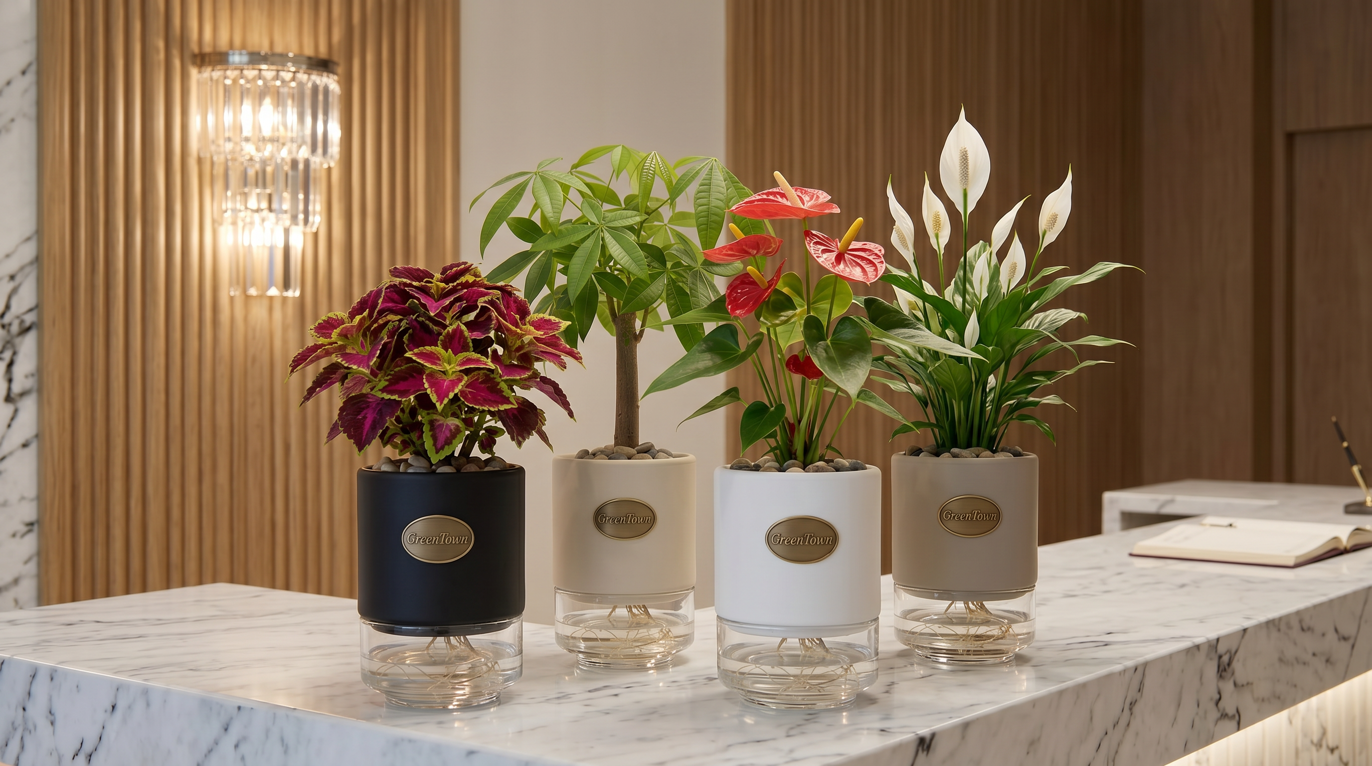 A tight staggered cluster of four identical GreenTown vases, grouped close together on a polished white Carrara marble reception counter in a luxury Dubai boutique hotel lobby. Collars mixed across matte cream, black and warm stone-grey. Each vase holds a different plant — a compact Coleus, a single-trunk Money Tree, an Anthurium with red flowers, and a Peace Lily in flower. Same squat cylindrical silhouette across all four, each with a small scalloped inlet at the bottom-front of the collar and a pressed antique-brass GreenTown medallion on the front face. Fluted oak paneling and a crystal sconce soften the background.
